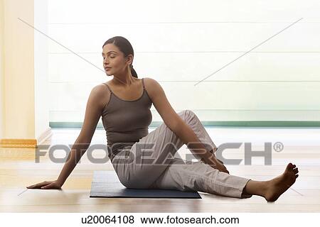 Young woman with eyes closed practicing yoga on mat View Large Photo Image Stock Photo - Young woman with eyes closed practicing yoga on mat. Fotosearch