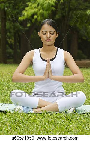 Stock Photo - Young woman with hands in prayer position . Fotosearch