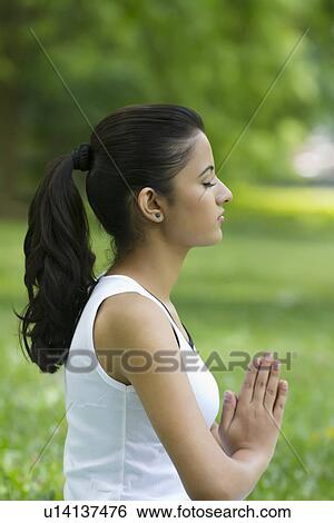 Young woman with hands in prayer position View Large Photo Image Stock Photograph - Young woman with hands in prayer position . Fotosearch