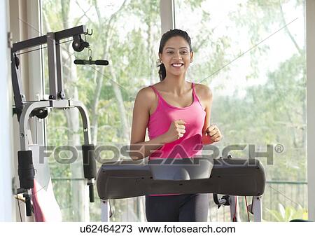 Young woman working out on treadmill View Large Photo Image Stock Image - Young woman working out on treadmill . Fotosearch