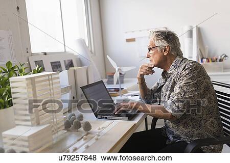 Stock Photo - Architect working on laptop in his office. Fotosearch