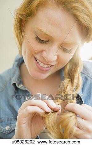 Attractive woman braiding hair View Large Photo Image Stock Image - Attractive woman braiding hair. Fotosearch
