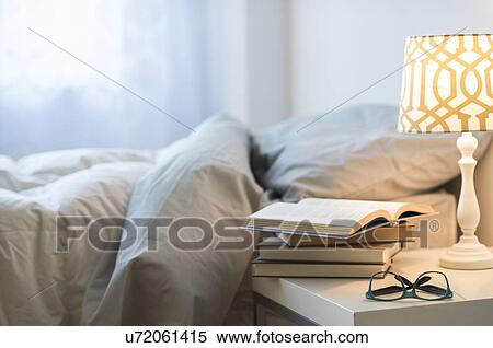Bed with lamp, books and glasses on bedside table View Large Photo Image Stock Photography - Bed with lamp, books and glasses on bedside table. Fotosearch