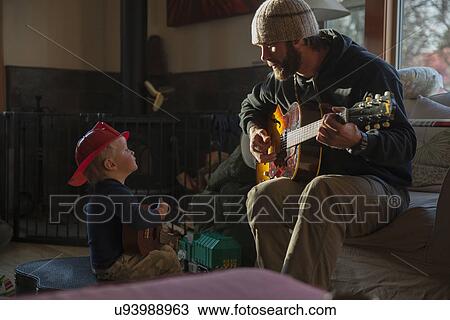 Boy (4-5) listening his dad playing guitar View Large Photo Image Stock Image - Boy (4-5) listening his dad playing guitar. Fotosearch