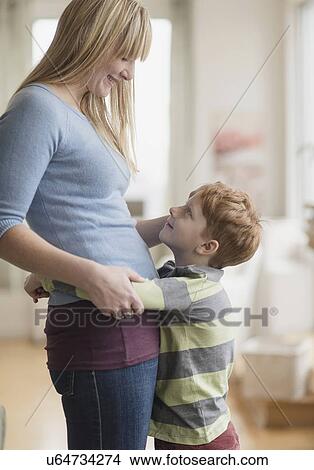 Picture - Boy (6-7) hugging his mother. Fotosearch