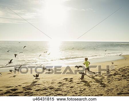Stock Photography - Boy (6-7) running on beach. Fotosearch