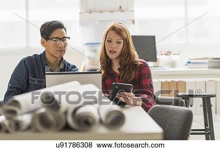 Stock Photo - Businesswoman and businessman working together in office. Fotosearch