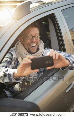 Car owner taking selfie View Large Photo Image Stock Image - Car owner taking selfie. Fotosearch