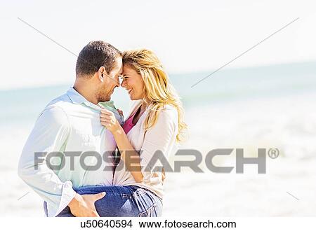 Couple embracing on beach View Large Photo Image Picture - Couple embracing on beach. Fotosearch
