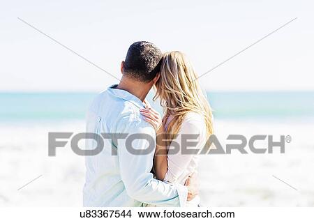 Picture - Couple embracing on beach. Fotosearch