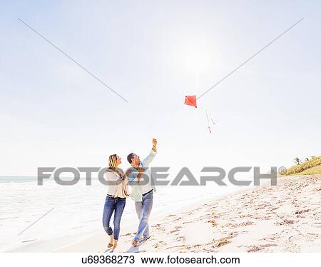 Couple on beach with kite View Large Photo Image Stock Image - Couple on beach with kite. Fotosearch