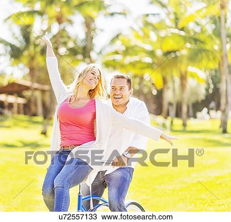 Couple riding on bike View Large Photo Image Stock Image - Couple riding on bike. Fotosearch
