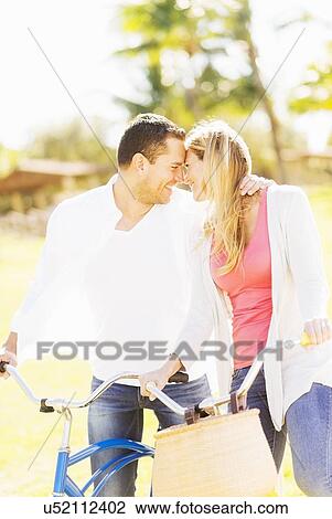 Stock Image - Couple riding on bikes. Fotosearch