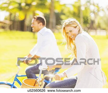 Stock Photograph - Couple riding on bikes. Fotosearch