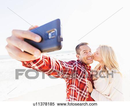 Couple taking selfie on beach View Large Photo Image Stock Photography - Couple taking selfie on beach. Fotosearch