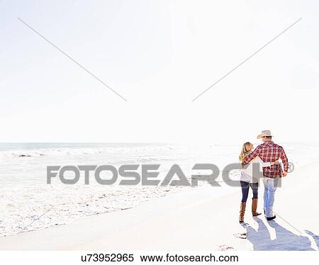Couple walking on beach View Large Photo Image Stock Photography - Couple walking on beach. Fotosearch