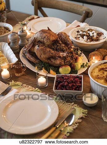 Stock Photo - Dining table filled with thanksgiving food. Fotosearch