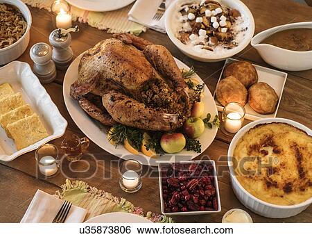 Stock Photograph - Dining table filled with thanksgiving food. Fotosearch