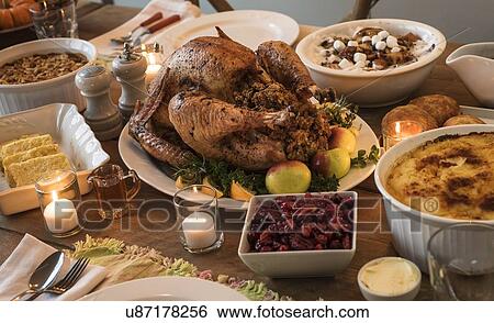 Stock Photograph - Dining table filled with thanksgiving food. Fotosearch