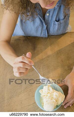 Elevated view of woman eating ice cream View Large Photo Image Stock Image - Elevated view of woman eating ice cream. Fotosearch