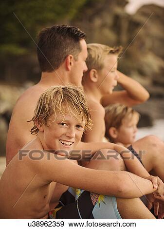 Family with three children (6-7, 10-11, 14-15) sitting on beach View Large Photo Image Stock Photo - Family with three children (6-7, 10-11, 14-15) sitting on beach. Fotosearch