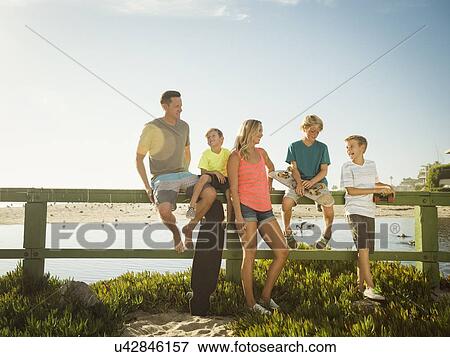 Family with three children (6-7, 10-11, 14-15) talking on beach View Large Photo Image Stock Photo - Family with three children (6-7, 10-11, 14-15) talking on beach. Fotosearch