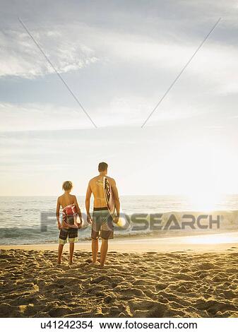 Picture - Father and son (14-15) looking at sea. Fotosearch
