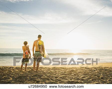 Stock Image - Father and son (14-15) looking at sea. Fotosearch