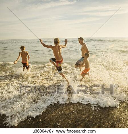 Father on beach with his three sons (6-7, 10-11, 14-15) View Large Photo Image Stock Photo - Father on beach with his three sons (6-7, 10-11, 14-15). Fotosearch