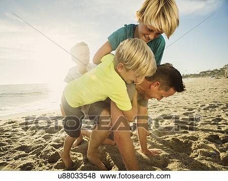 Father playing with his sons (6-7, 10-11, 14-15) on beach View Large Photo Image Stock Photo - Father playing with his sons (6-7, 10-11, 14-15) on beach. Fotosearch