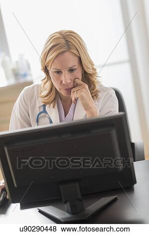 Stock Photo - Female doctor using computer. Fotosearch