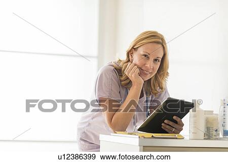 Stock Photo - Female doctor using tablet pc. Fotosearch