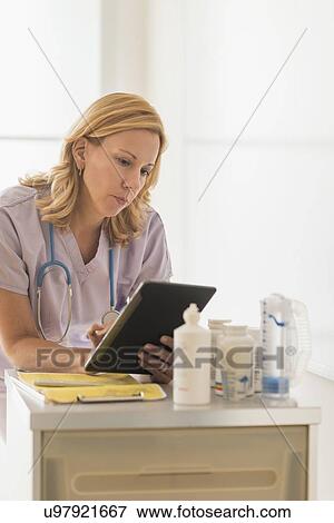 Female doctor using tablet pc View Large Photo Image Stock Photo - Female doctor using tablet pc. Fotosearch