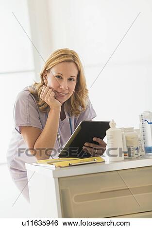 Stock Photograph - Female doctor using tablet pc. Fotosearch