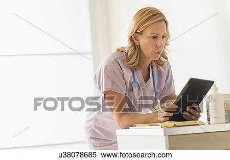 Stock Photography - Female doctor using tablet pc. Fotosearch