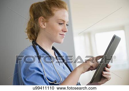 Female nurse using digital tablet View Large Photo Image Stock Image - Female nurse using digital tablet. Fotosearch