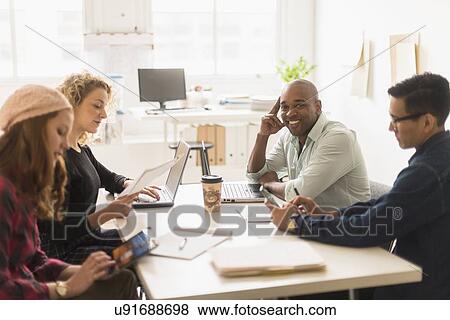 Friends having business meeting in office View Large Photo Image Stock Photo - Friends having business meeting in office. Fotosearch