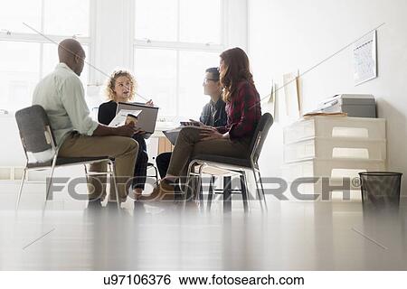 Friends having business meeting in office View Large Photo Image Stock Photograph - Friends having business meeting in office. Fotosearch
