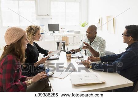 Stock Photography - Friends having business meeting in office. Fotosearch