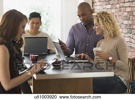 Friends sitting in cafe, using laptops and digital tablets View Large Photo Image Stock Image - Friends sitting in cafe, using laptops and digital tablets. Fotosearch