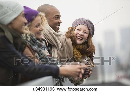 Stock Image - Friends standing on bridge and laughing. Fotosearch