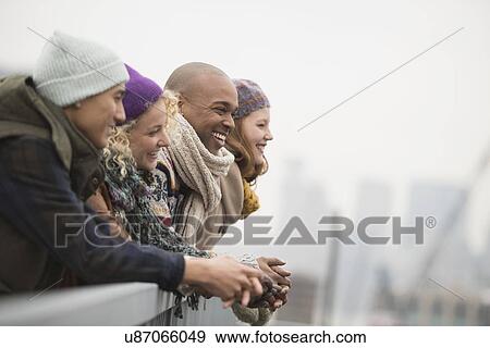 Friends standing on bridge and laughing View Large Photo Image Stock Photo - Friends standing on bridge and laughing. Fotosearch