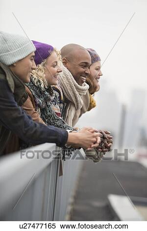 Stock Photography - Friends standing on bridge and laughing. Fotosearch