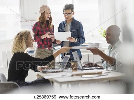 Stock Photo - Friends working in office. Fotosearch
