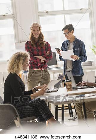 Stock Photograph - Friends working in office. Fotosearch