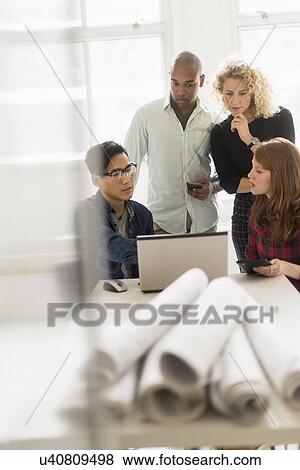 Friends working on project in office View Large Photo Image Stock Photo - Friends working on project in office. Fotosearch