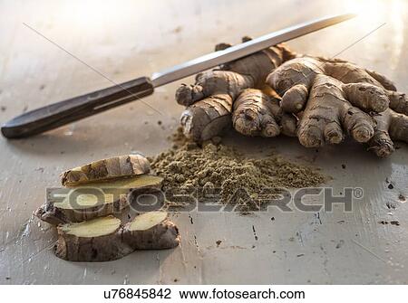 Stock Image - Ginger root and ginger powder on white. Fotosearch
