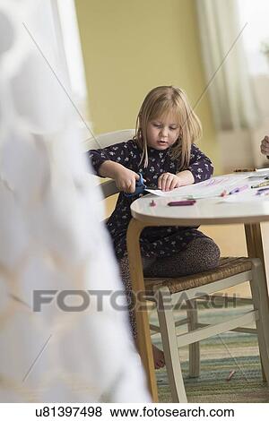 Girl (4-5) playing at table in family room View Large Photo Image Stock Photo - Girl (4-5) playing at table in family room. Fotosearch
