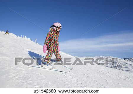 Girl (8-9) skiing in mountains View Large Photo Image Stock Image - Girl (8-9) skiing in mountains. Fotosearch