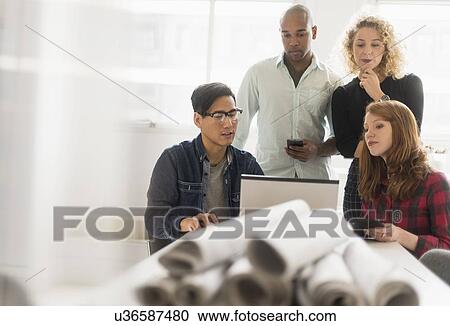 Stock Image - Group of business people working together in office. Fotosearch